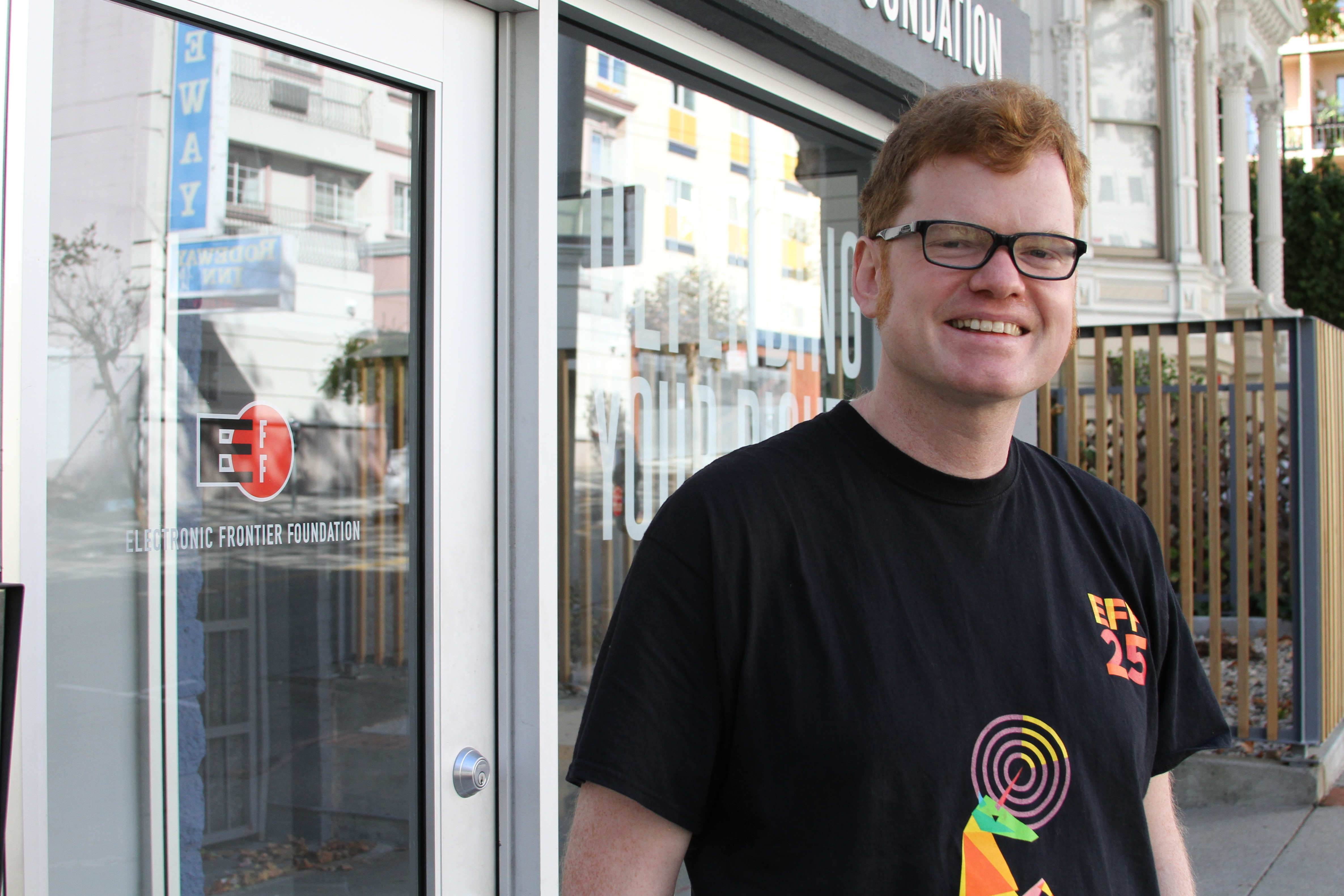 Elliot smiling, wearing a black shirt with a rainbow unicorn and the text "EFF25".