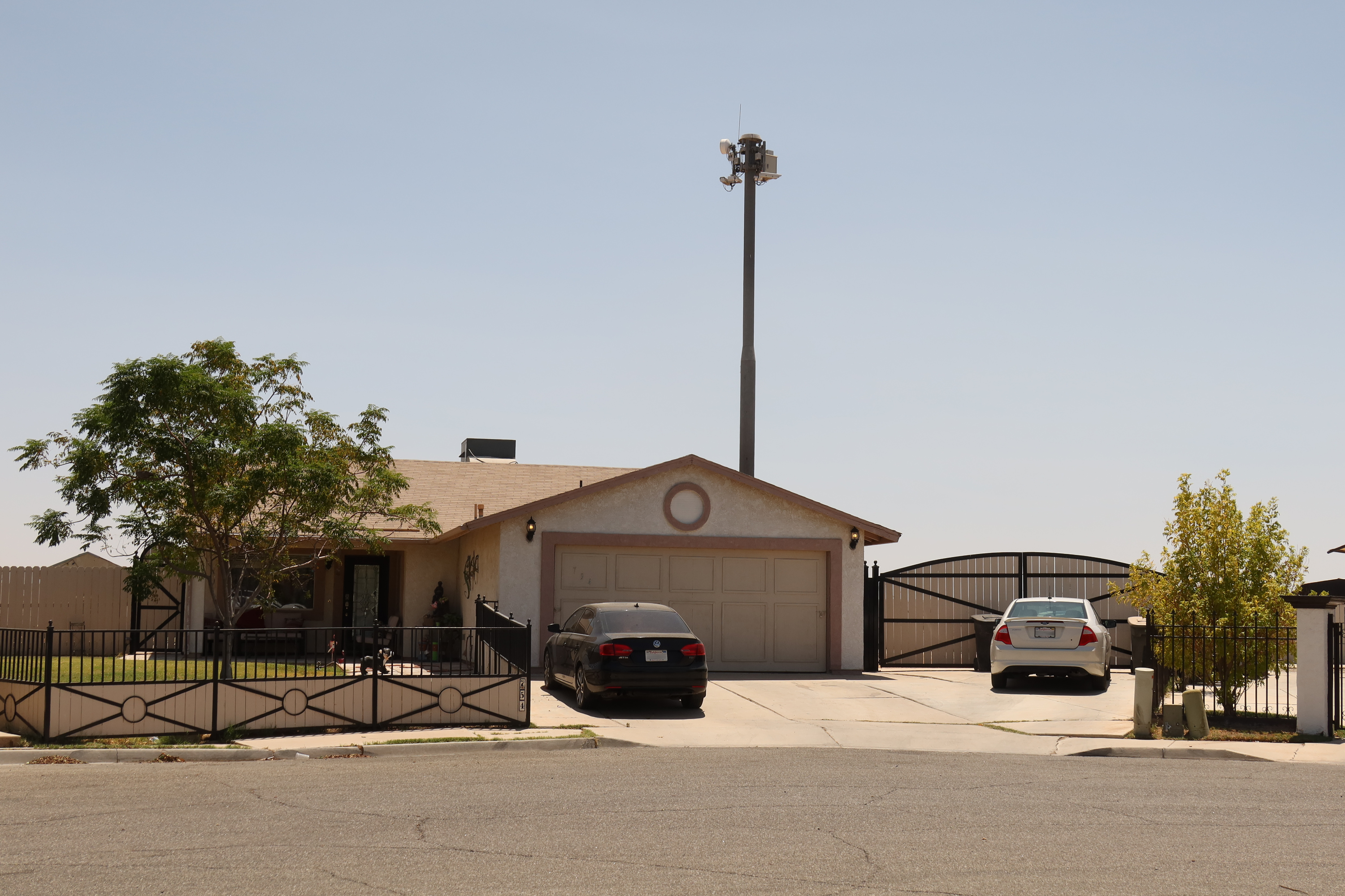 A surveillance tower over a one-story home. 