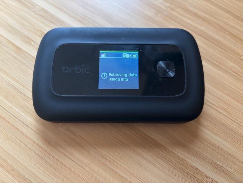 A picture of Rayhunter running on the orbic hotspot. Orbic is about the size of a small cell phone and the rayhunter UI is a single green line at the top