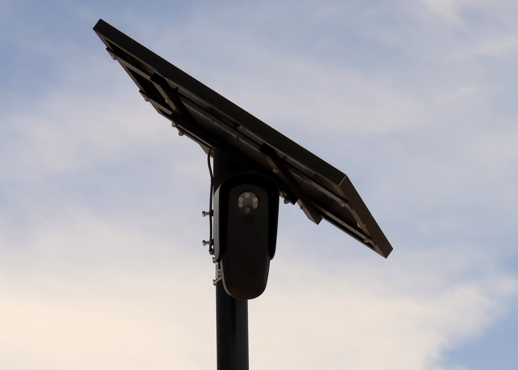 A black Flock Safety camera with a small solar panel A black Flock Safety camera with a small solar panel