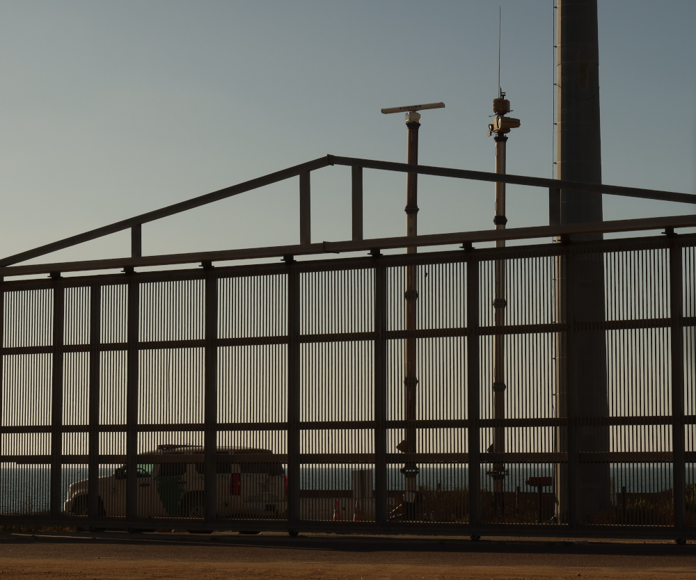 An Anduril surveillance tower at the borde fence with a Border Patrol vehicle. An Anduril surveillance tower at the borde fence with a Border Patrol vehicle.