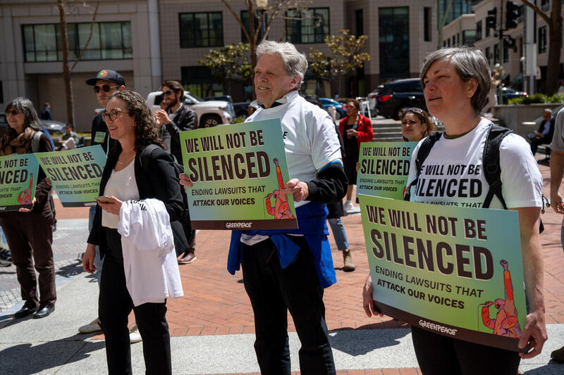 People standing at a Greenpeace rally